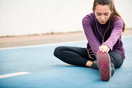 Woman stretching after a run to take care of muscles